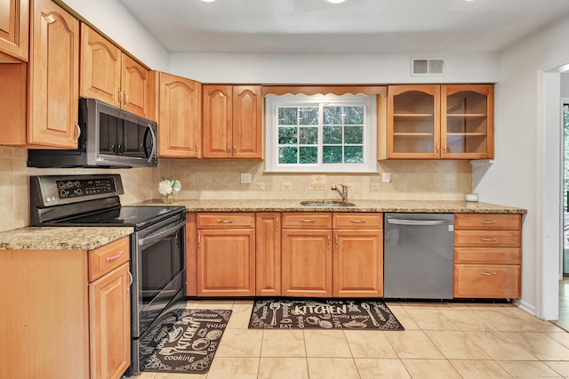 44 Columbus Pl Unit 2, Stamford, CT 06907 - kitchen featuring stainless steel appliances, light stone countertops, decorative backsplash, glass insert cabinets, and a sink