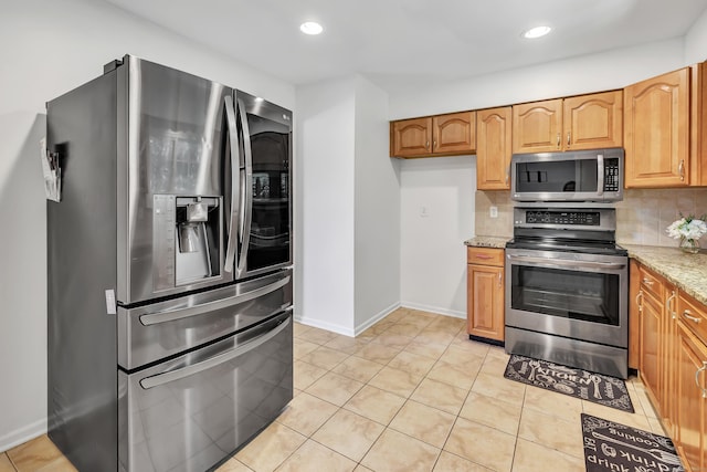 44 Columbus Pl Unit 2, Stamford, CT 06907 - kitchen with stainless steel appliances, backsplash, light tile patterned floors, light stone countertops, and recessed lighting