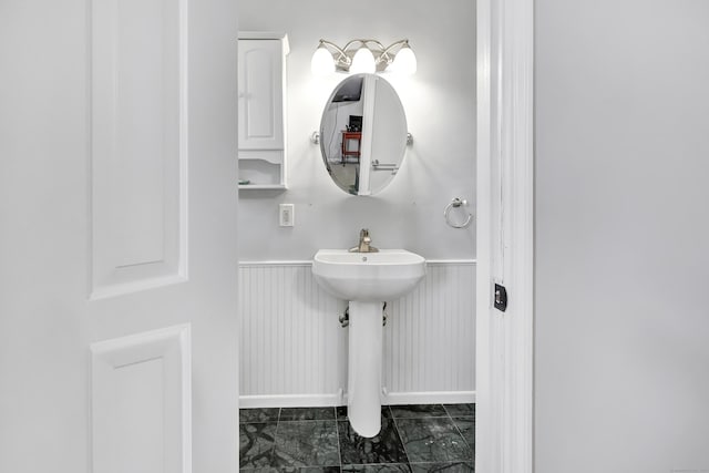 44 Columbus Pl Unit 2, Stamford, CT 06907 - bathroom with baseboards, marble finish floors, a wainscoted wall, and a sink
