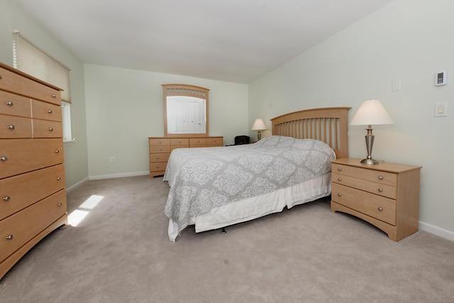 bedroom featuring baseboards and light carpet
