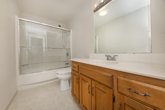 full bathroom with vanity, combined bath / shower with glass door, tile patterned flooring, and toilet