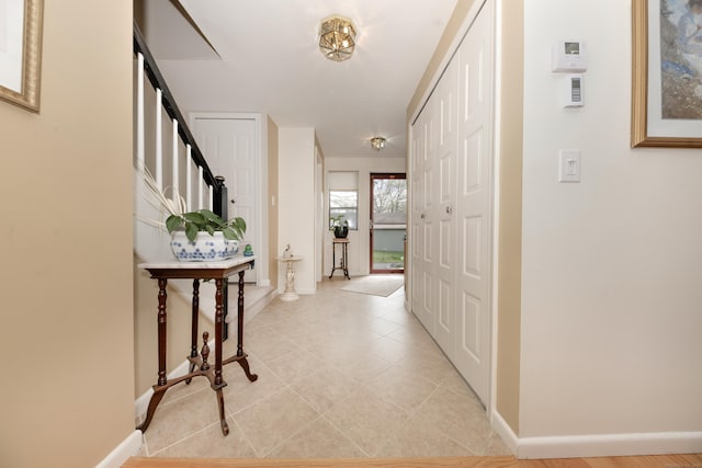 entrance foyer featuring baseboards, stairs, and light tile patterned floors