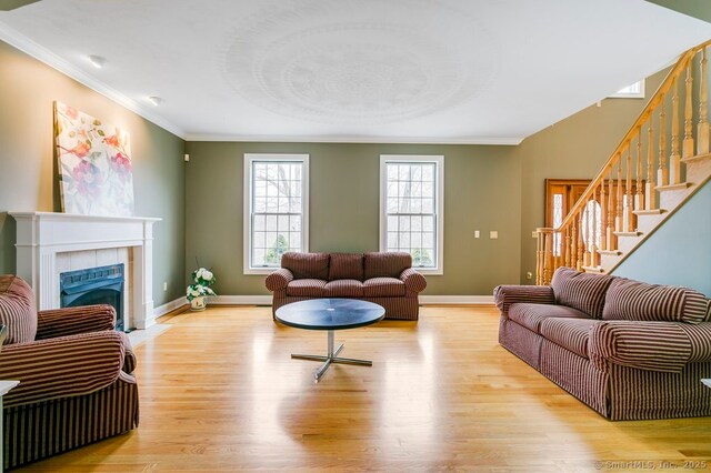 32 Village Dr, East Lyme, CT 06333 - living area with ornamental molding, light wood-style flooring, stairs, baseboards, and a fireplace