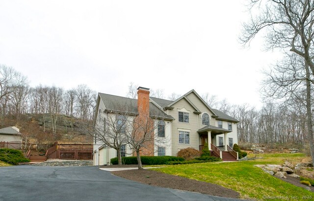 32 Village Dr, East Lyme, CT 06333 - traditional-style home featuring a chimney, concrete driveway, a front yard, and a garage