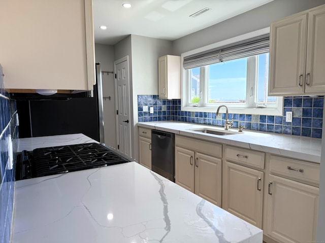 kitchen with a sink, black dishwasher, tasteful backsplash, white cabinetry, and light stone countertops