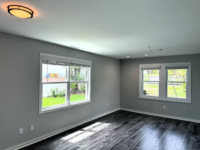 empty room with dark wood-style floors, baseboards, and recessed lighting
