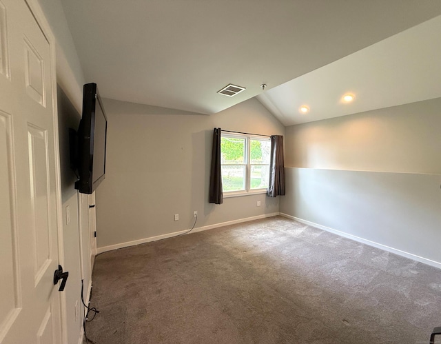 empty room with carpet floors, vaulted ceiling, and baseboards