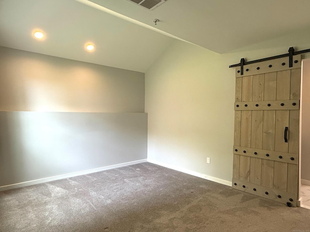 carpeted empty room with a barn door, baseboards, a pendent fire sprinkler, lofted ceiling, and recessed lighting