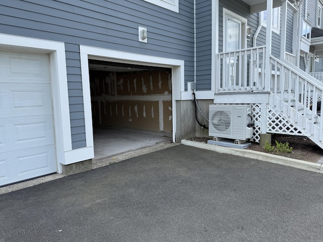 garage featuring a cooling unit and asphalt driveway