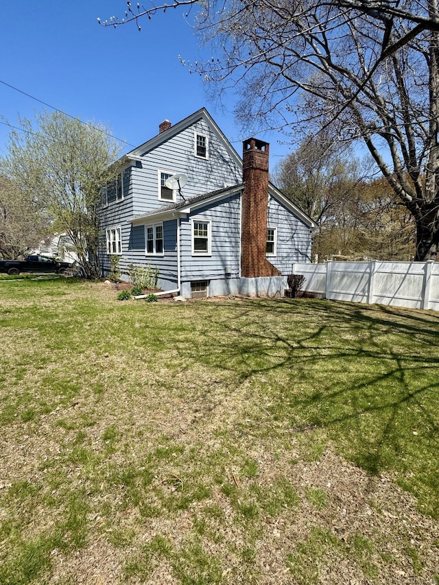 572 Forbes St, East Hartford, CT 06118 - rear view of property with fence, a chimney, and a lawn