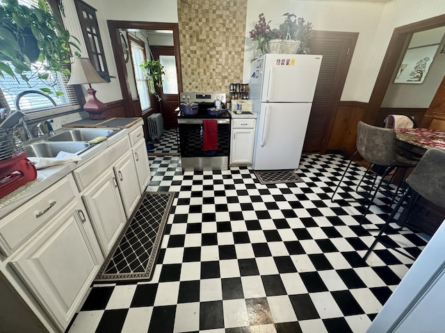 572 Forbes St, East Hartford, CT 06118 - kitchen featuring a sink, white cabinets, freestanding refrigerator, and stainless steel range with electric cooktop