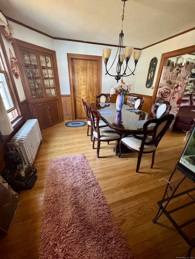 572 Forbes St, East Hartford, CT 06118 - dining room with wood walls, a chandelier, hardwood / wood-style floors, a wainscoted wall, and ornamental molding