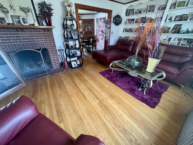 572 Forbes St, East Hartford, CT 06118 - living room with crown molding, built in features, wood finished floors, and a fireplace