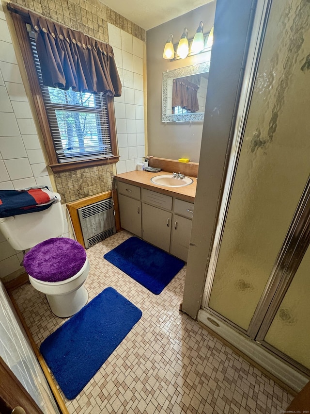 572 Forbes St, East Hartford, CT 06118 - full bathroom with heating unit, tile walls, vanity, and a stall shower