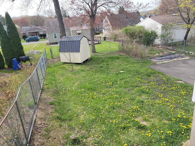 view of yard with an outbuilding, fence, and a storage shed