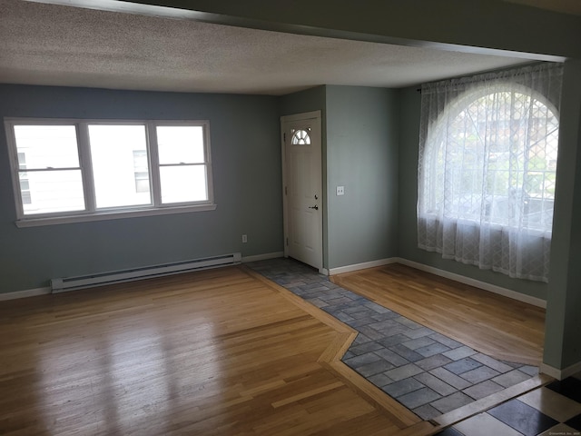 entryway with baseboards, baseboard heating, and wood finished floors