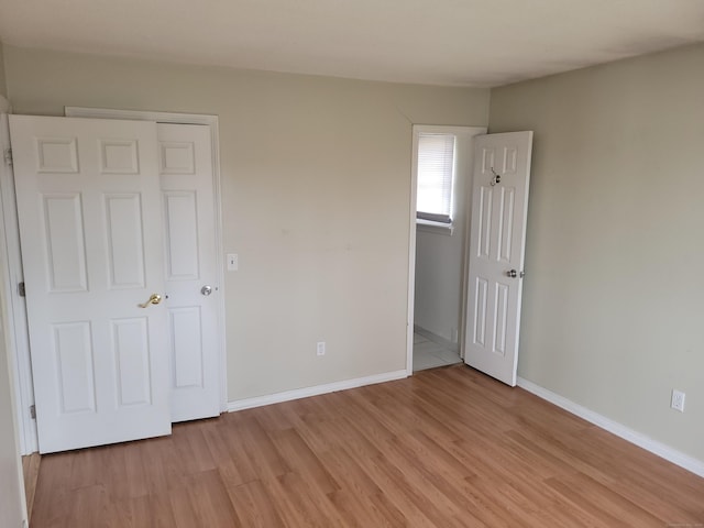 unfurnished bedroom with baseboards and light wood finished floors
