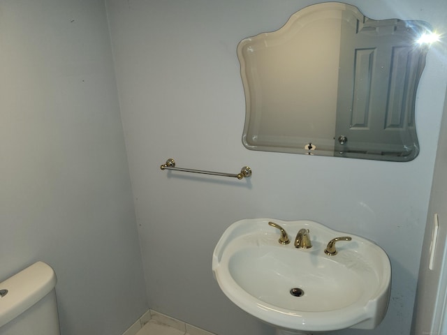 half bath featuring toilet and a sink