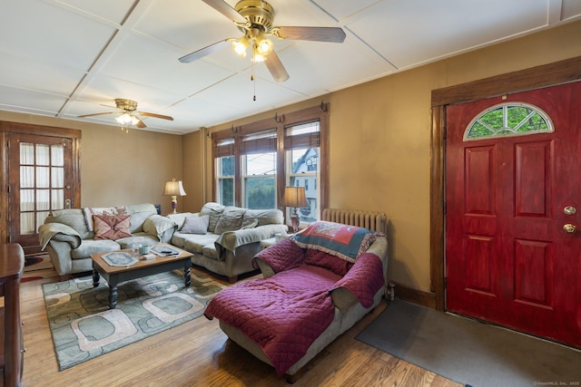 living area with wood finished floors, a ceiling fan, and radiator heating unit