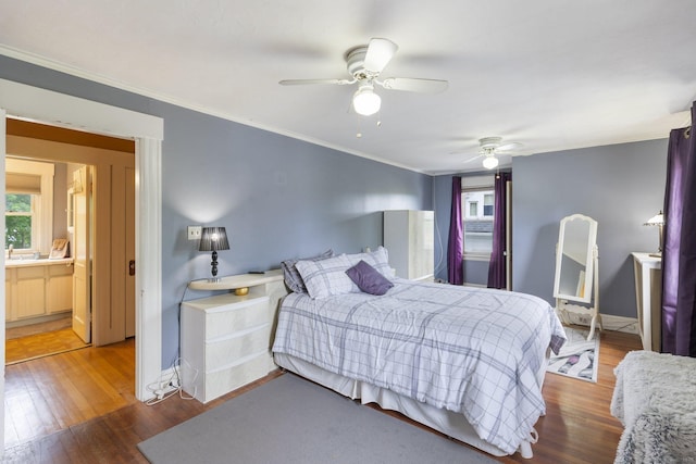 bedroom with wood finished floors, crown molding, baseboards, and a ceiling fan