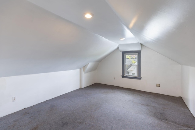 additional living space featuring carpet and vaulted ceiling