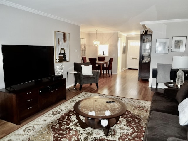 living room featuring baseboards, ornamental molding, and wood finished floors