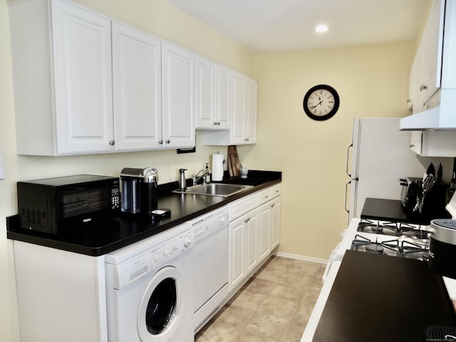 kitchen featuring washer / dryer, white appliances, a sink, and white cabinetry