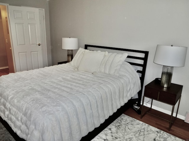 bedroom with baseboards and wood finished floors