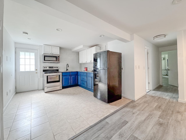 4 Robert Ln, Westport, CT 06880 - kitchen featuring stainless steel appliances, blue cabinetry, decorative backsplash, white cabinetry, and light wood-style flooring