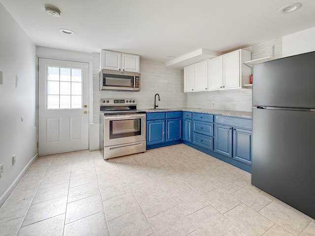 4 Robert Ln, Westport, CT 06880 - kitchen featuring appliances with stainless steel finishes, open shelves, blue cabinets, tasteful backsplash, and white cabinetry