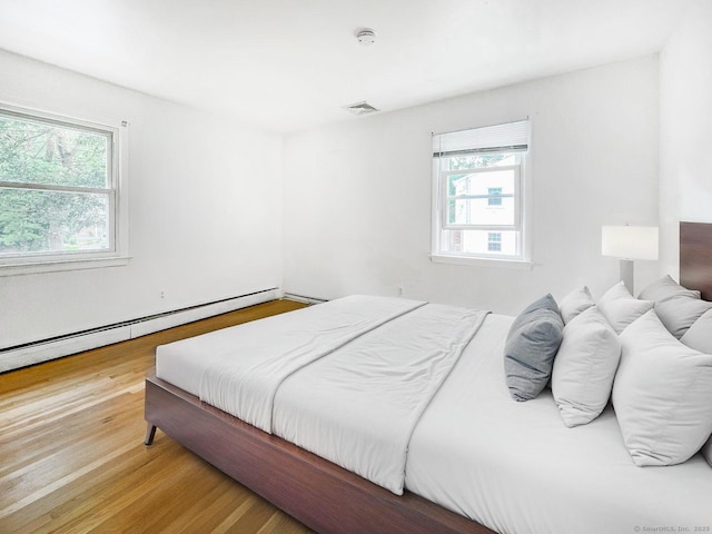 4 Robert Ln, Westport, CT 06880 - bedroom featuring multiple windows, a baseboard radiator, and wood finished floors