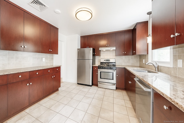 4 Robert Ln, Westport, CT 06880 - kitchen with appliances with stainless steel finishes, backsplash, light tile patterned floors, under cabinet range hood, and light stone counters