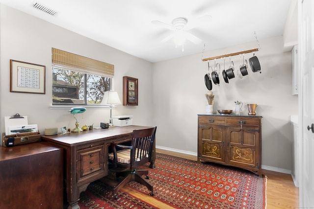 home office featuring wood finished floors, a ceiling fan, and baseboards