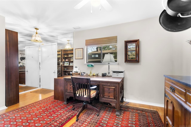 office featuring wood finished floors, ceiling fan, and baseboards
