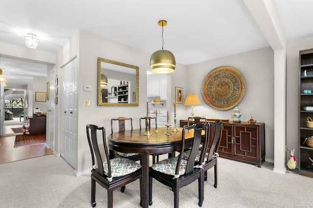 dining space with light carpet and baseboards