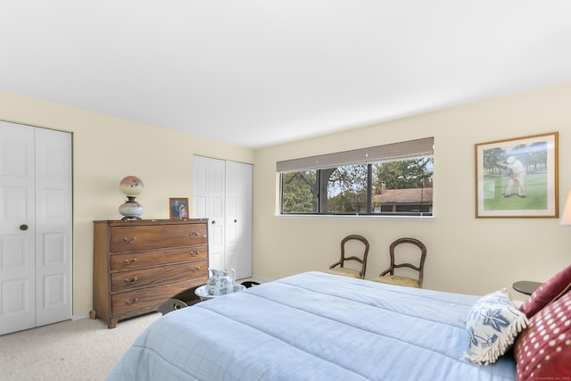 bedroom with multiple closets, carpet floors, and baseboards