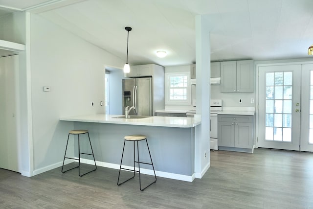61 Forest St, Naugatuck, CT 06770 - kitchen with white electric range oven, stainless steel fridge with ice dispenser, a peninsula, light wood finished floors, and a kitchen breakfast bar