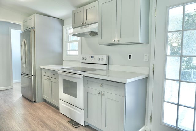 61 Forest St, Naugatuck, CT 06770 - kitchen with under cabinet range hood, electric stove, freestanding refrigerator, light wood-style floors, and light countertops