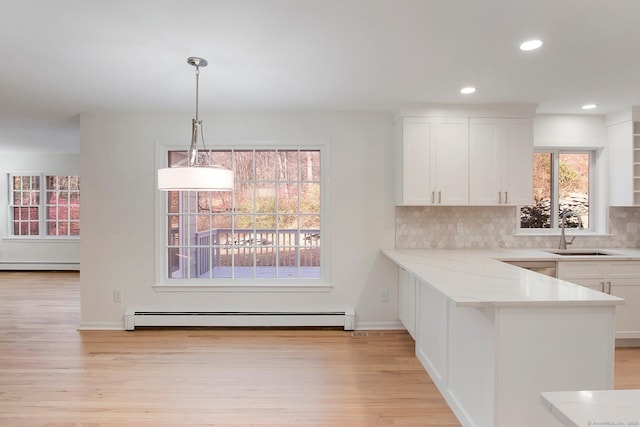 1510 Congress St, Fairfield, CT 06825 - kitchen with a baseboard radiator, a baseboard heating unit, light wood-style flooring, white cabinetry, and recessed lighting