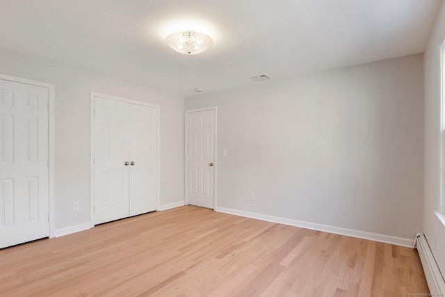 1510 Congress St, Fairfield, CT 06825 - unfurnished bedroom featuring a baseboard heating unit, light wood-style floors, and a closet