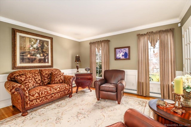 living area with crown molding, wainscoting, wood finished floors, and baseboard heating