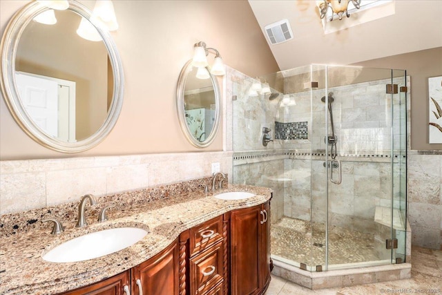 bathroom with tile walls, a sink, lofted ceiling, and a stall shower
