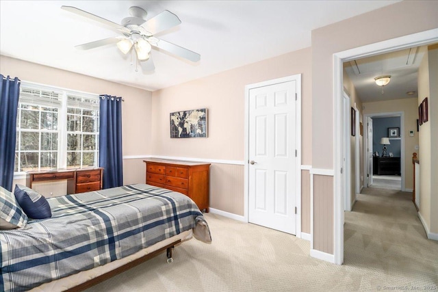 bedroom with baseboards, attic access, ceiling fan, and light carpet