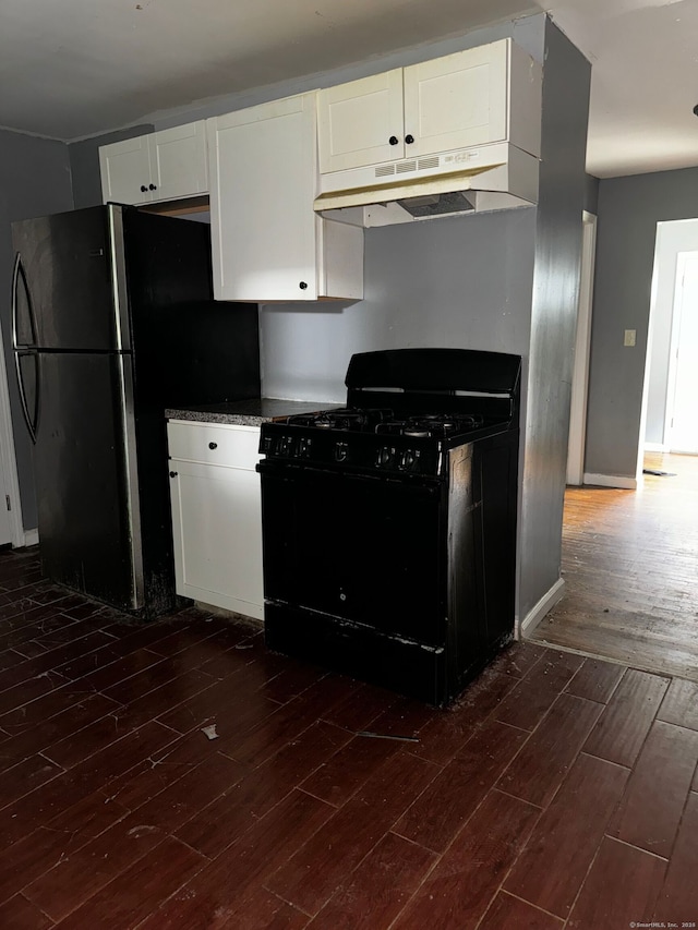 254 Starr St, New Haven, CT 06511 - kitchen featuring black gas range, under cabinet range hood, dark wood finished floors, white cabinetry, and freestanding refrigerator