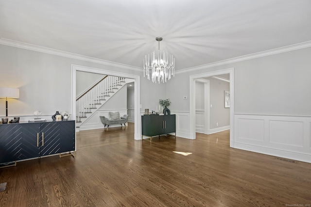 dining space with a chandelier, stairway, crown molding, wood finished floors, and a wainscoted wall