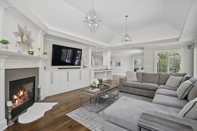 living room with a chandelier, ornate columns, dark wood-style flooring, a fireplace with flush hearth, and recessed lighting