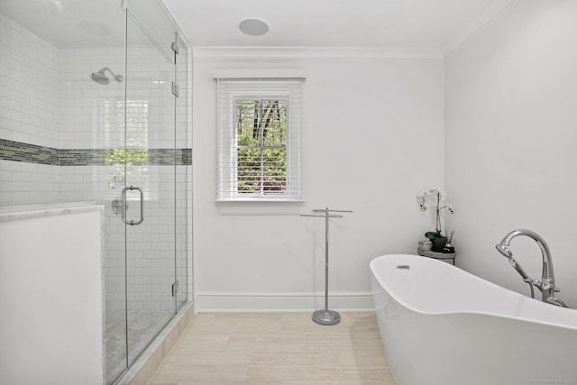 full bath with a shower stall, a freestanding bath, crown molding, and baseboards