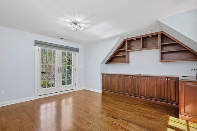 additional living space with dark wood finished floors and baseboards