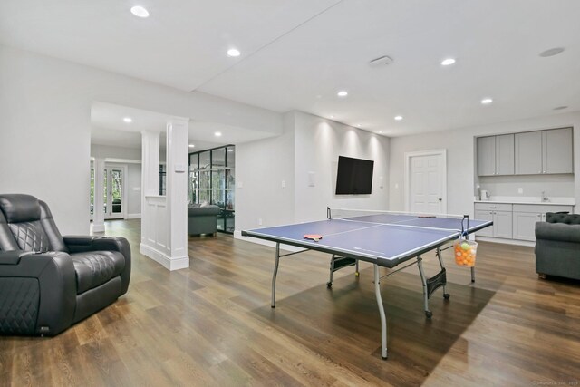 rec room featuring recessed lighting, wood finished floors, ornate columns, and baseboards