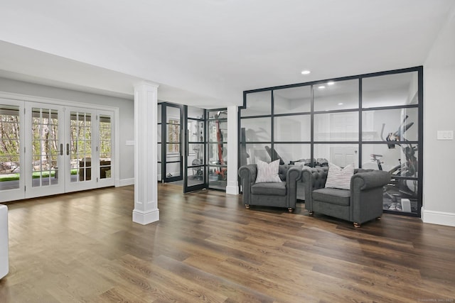sitting room featuring french doors, baseboards, decorative columns, wood finished floors, and recessed lighting